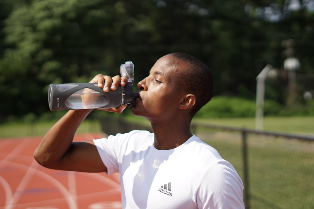 Runner hydrating with water bottle during long distance marathon race
