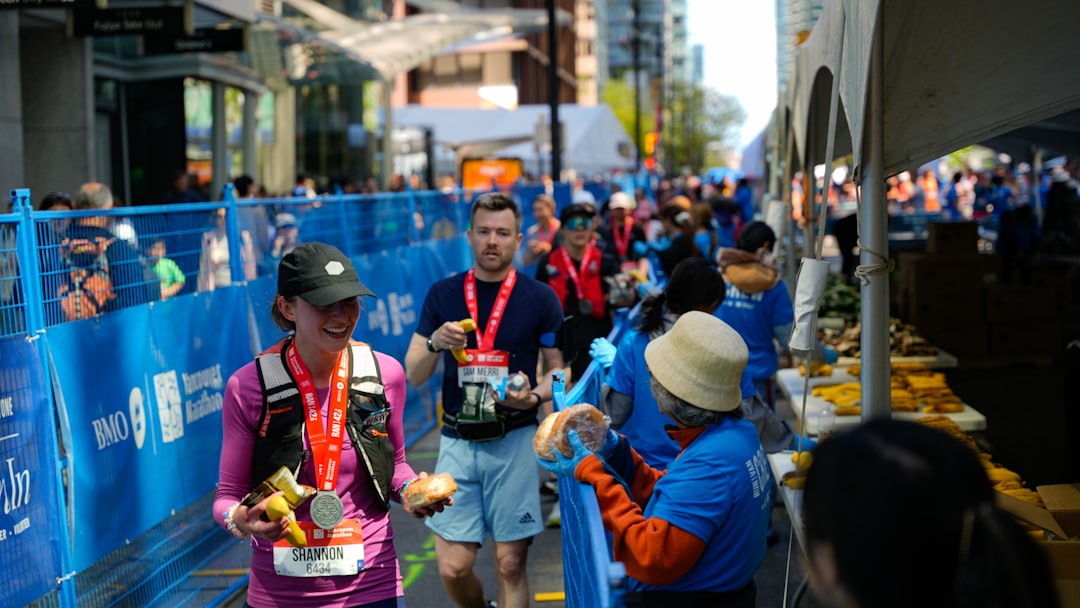 Ultramarathon runner refueling at an aid station with water bottles and nutrition supplies